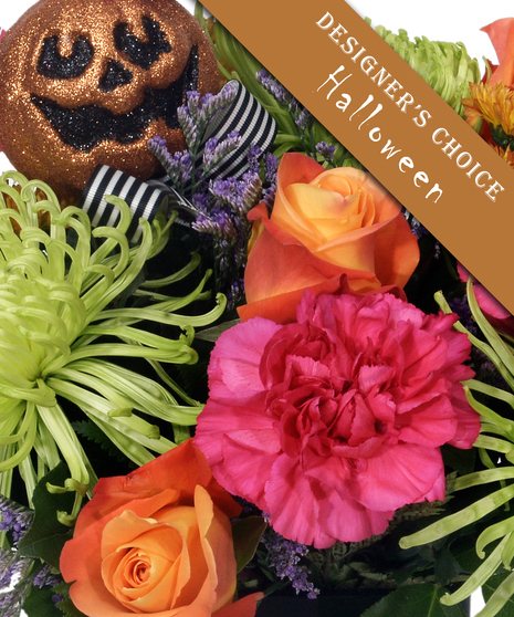 close up of example Halloween bouquet with pink carnations, orange roses, and glittery pumpkin skull