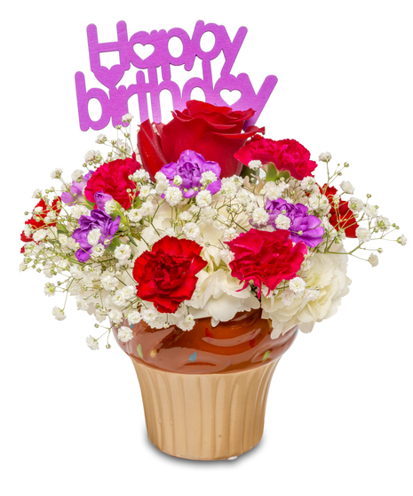 A ceramic container with white hydrangeas, colorful miniature carnations, and a single red rose in the center, topped with a happy birthday pick.