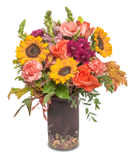 Festive fall vase with autumn leaves at the base, filled with sunflowers, carnations, roses, fall mums, and preserved oak leaves, capturing the vibrant colors of the season.