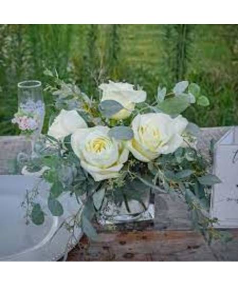 Elegant arrangement of white roses with eucalyptus in a clear glass vase, designed by Walter Knoll Florist for a timeless, simple yet luxurious floral display.