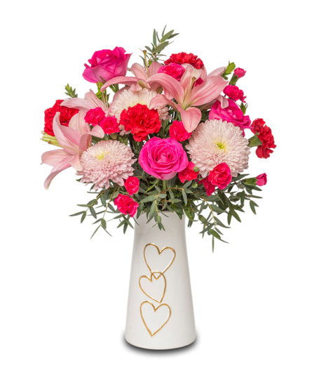 XOXO floral arrangement with red carnations, pink roses, lilies, and linette mums in pink and red hues. Designed as a sweet Valentine’s Day gift.