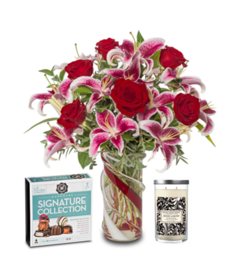 A bouquet of lilies and roses, paired with a honey almond scented candle and a 7-piece box of chocolates, creating an elegant and thoughtful gift set.