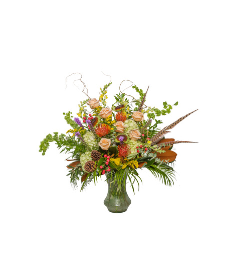 Large vase arrangement of green hydrangeas, peach roses, red berries, and mixed greenery with accents like protea, sunflower centers, and pinecones in a natural style