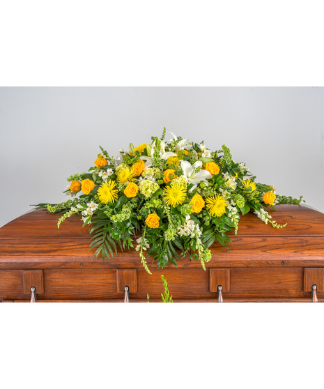 Serenity Casket Spray: A stunning floral arrangement in greens, whites, and yellows, a heartfelt tribute to a beloved soul