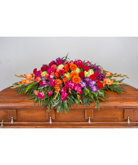 hot pink and orange casket spray in jubilant celebration of life