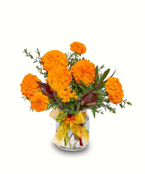 Vase arrangement of orange marigolds with textured greenery including red leucadendron and eucalyptus, honoring Day of the Dead, handcrafted by Walter Knoll Florist.