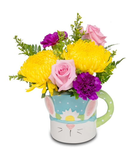 An oversized mug featuring a cute bunny gnome, filled with either a vibrant gerbera plant or a small floral arrangement, adding whimsy to home decor.