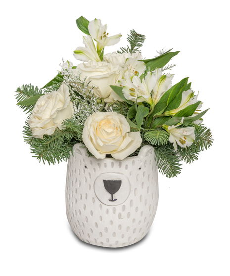 White floral arrangement with white roses, white alstroemeria, and wintergreens in a polar bear pot