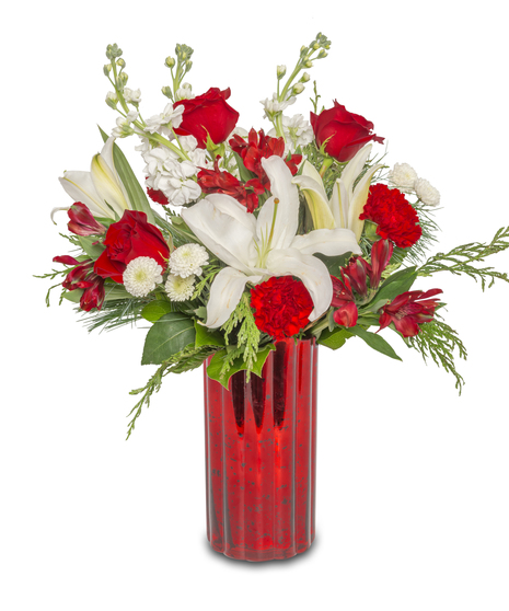 Winter's Haven floral arrangement in a red glass vase with white lilies, red roses, carnations, button mums, red alstroemeria, cedar, and pine wintergreens