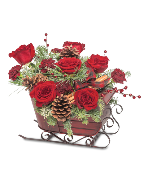 Holiday sleigh centerpiece with red roses, pinecones, cinnamon sticks, evergreen branches, and red berries