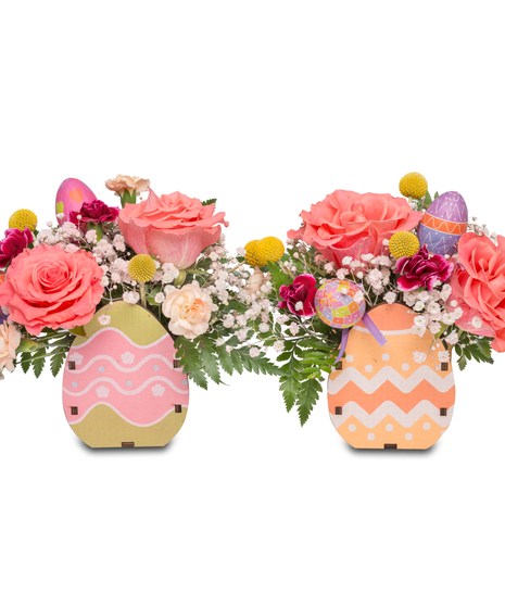 A petite wooden crate filled with bright florals including baby's breath, miniature carnations, and peach roses, adding a touch of springtime charm.